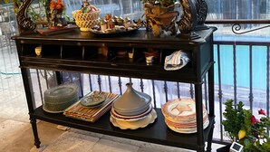 A display table with various decorative items and plants. - Charming artist's house. (Nîmes)