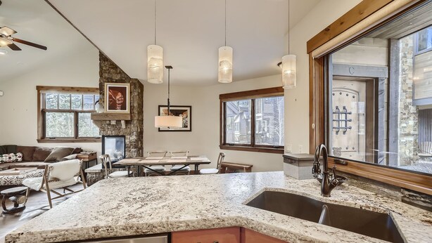 A modern kitchen with granite countertops, a stainless steel sink, and pendant lighting. - Luxury 2 Bedroom Townhome Close to Main Street!! (Frisco)