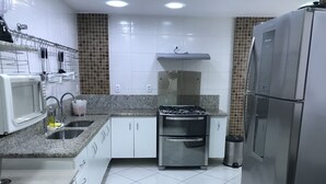 A compact kitchen with white cabinets, a stainless steel stove, and a refrigerator. - Spectacular Triplex Penthouse on Morro Beach (ES)