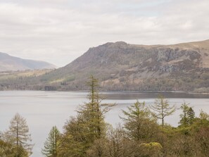 A mountainous landscape with a lake and trees in the foreground. - Derwent Haven (Keswick)