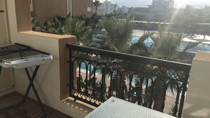 A balcony with a metal grill, a small table, and a drying rack. - Superb studio for vaccinations (Sousse)