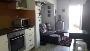 A compact kitchen with a microwave, oven, and a small dining area with a table and chairs.
