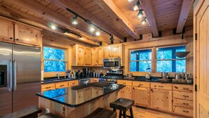 Una cocina moderna con armarios de madera, electrodomésticos de acero inoxidable y una isla grande con taburetes.