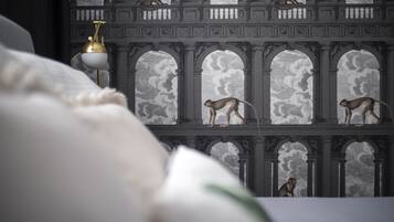 Ein Zimmer mit einem Bett, einer Lampe und einer Wand mit Affiguren.