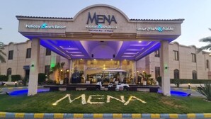 The entrance of MENA Holiday Beach Resort with a clear sign, a covered entrance, and a well-maintained lawn. - Mena Holiday Beach Resort Half Moon Bay (Dammam)