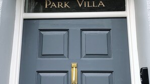 A dark grey door with the name 'Park Villa' in gold lettering above it.