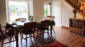 A dining area with a table set for four, a chandelier, and a staircase.