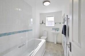 Bathtub, hair dryer, towels, shampoo