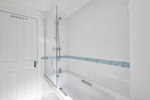 Bathtub, hair dryer, towels, shampoo