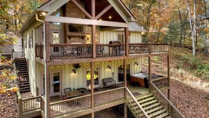 Eine zweistöckige Holzhütte mit Balkon, Kamin und Whirlpool.