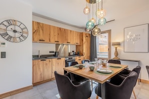 Enjoy meals in this well-equipped kitchen with a central island, stainless steel appliances, and a dining table for six.