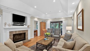 A spacious living room with a fireplace, a flat-screen TV, and comfortable seating. - River Views at Inlet Cove! Community Dock and Pool (Seabrook Island)