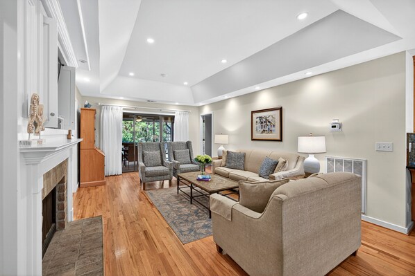 A spacious living room with a fireplace, a sofa set, and a dining area. - River Views at Inlet Cove! Community Dock and Pool (Seabrook Island)