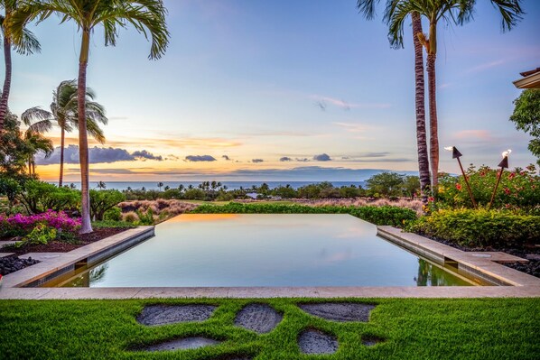 A pool with a view of the ocean and palm trees. - Exquisite 4BR Hainoa Estate 122 at Hualalai – Ocean Views & Infinity-Edge Pool (Kailua Kona)