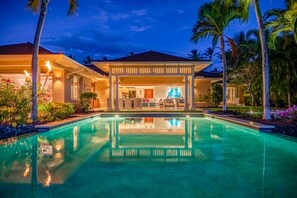 A resort with a swimming pool, a covered outdoor seating area, and palm trees. - Exquisite 4BR Hainoa Estate 122 at Hualalai – Ocean Views & Infinity-Edge Pool (Kailua Kona)