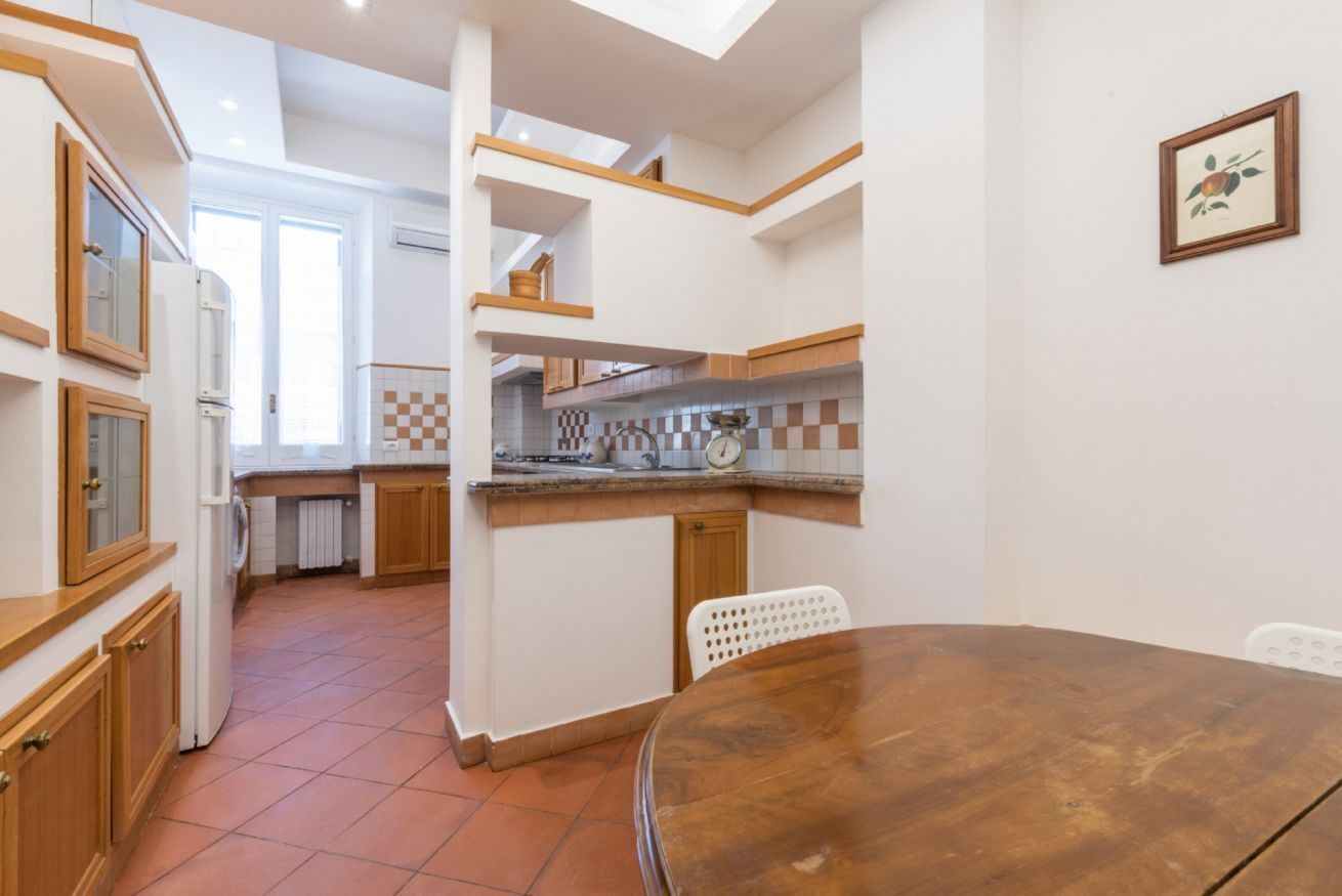 Una cucina con tavolo da pranzo, mobili in legno e uno schienale a scacchi.