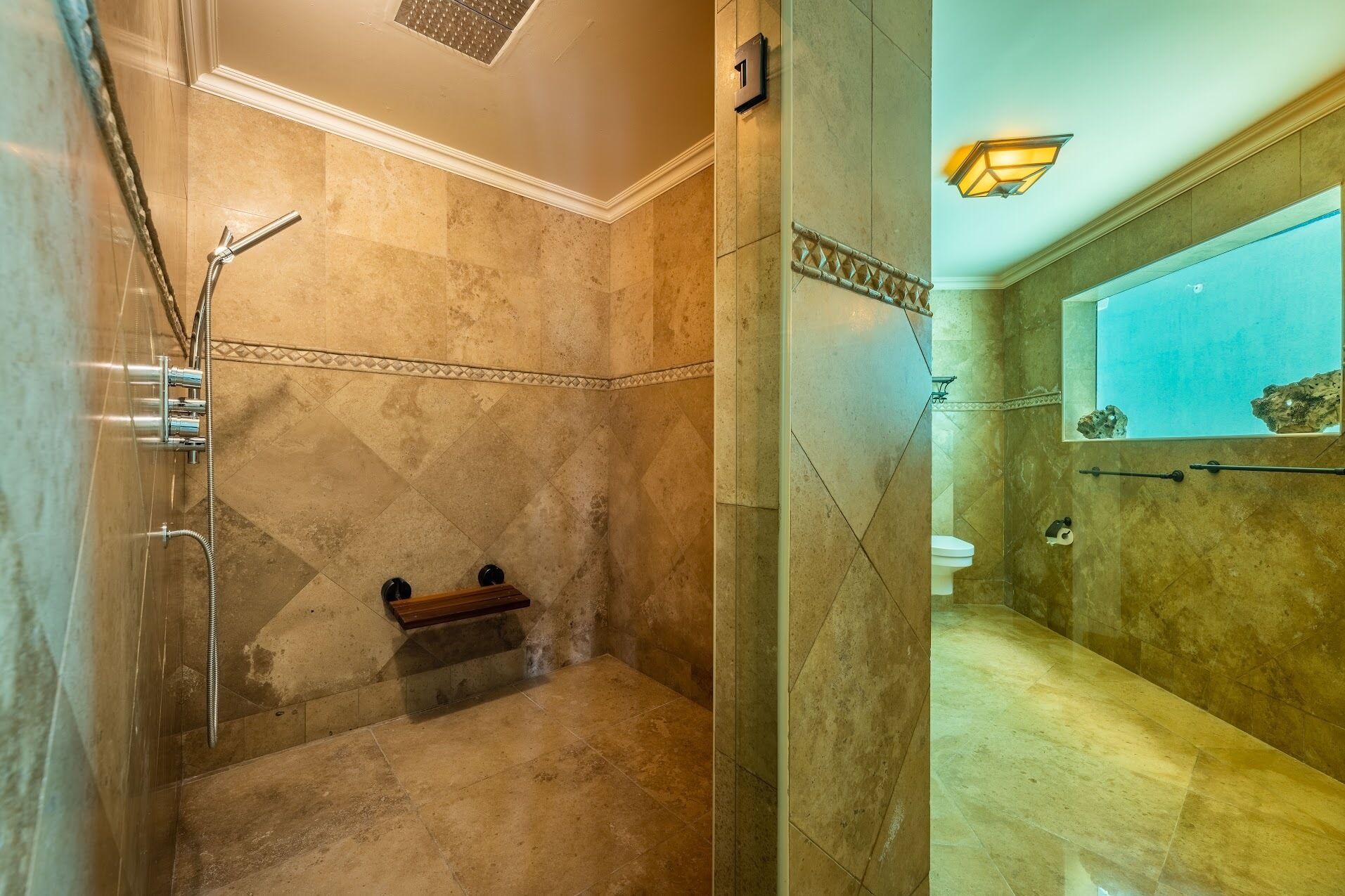 A bathroom with a shower, toilet, and a bench.