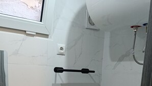 Un baño con inodoro, lavamanos y ducha.