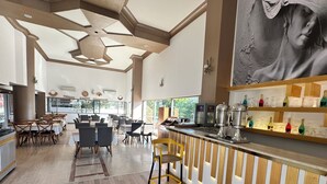 A modern restaurant with wooden flooring, a bar area with a variety of bottles, and a dining area with tables and chairs. - Silver Tower Family Apart Otel (Kusadasi)