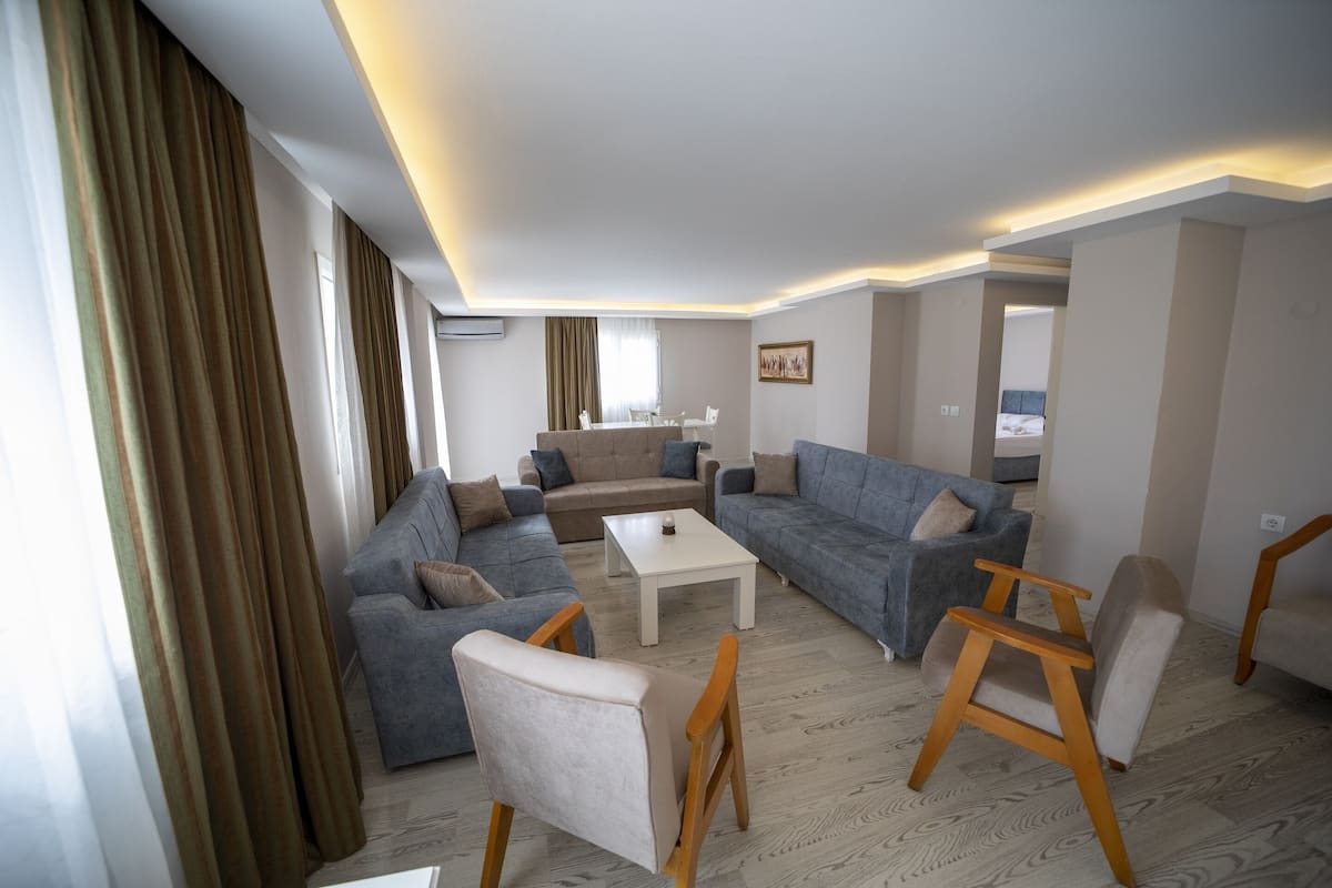 A modern living room with a sofa set, a coffee table, and a wooden chair.