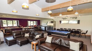 Eine großzügige Lounge mit Billardtisch, Ledersofas und einem Essbereich.
