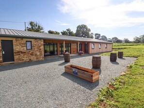 A building with a stone facade, wooden doors, and a gravel driveway.