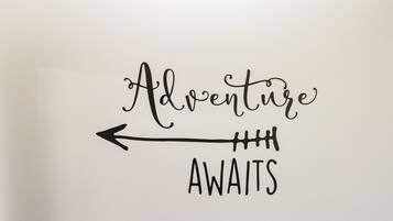 A wall with the words "Adventure Awaits" and an arrow pointing to the left.