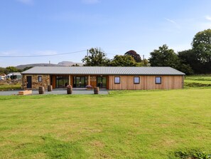 A lodge with a stone facade, large windows, and a metal roof.