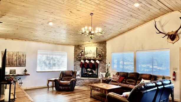 A cozy living room with a fireplace, leather sofas, a wooden ceiling, and a mounted deer head. - BearLuckLodge! Amazing Cabin-Hot Tub, Views, Game Room/Arcade, Location, Peloton (Ruidoso)