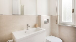 Ein Badezimmer mit Waschbecken, Spiegel und Toilette.
