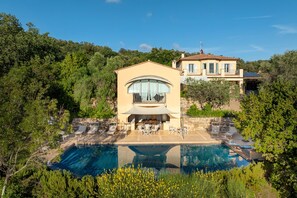 A villa with a swimming pool, outdoor seating, and a view of the surrounding greenery. - Villa Le Cave 12, Emma Villas (Campalto)