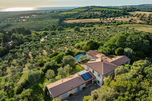 A two-story house with a swimming pool, surrounded by dense greenery and hilly terrain. - Villa Le Cave 12, Emma Villas (Campalto)