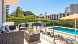 Un espace piscine sur le toit, comprenant des chaises longues, une table de billard et un coin salon abrité.