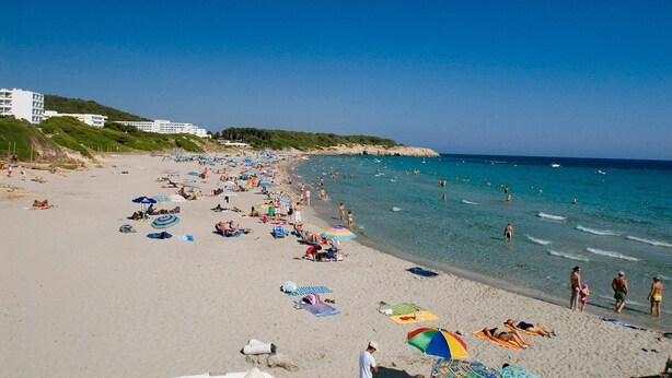 A crowded beach with people sunbathing and swimming, and buildings in the background. - Villa Lavanda by Villa Plus (Sant Tomas)