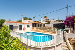 Une propriété résidentielle dotée d’une piscine, d’une terrasse clôturée et offrant une vue sur les maisons voisines.