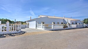 A white building with a tiled roof, a gated entrance, and a clear blue sky. - Villa Casa Miguel by Villa Plus (Vale Rebelho)