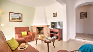 A living room with a fireplace, a television, and a sofa. - Villa Casa Miguel by Villa Plus (Vale Rebelho)