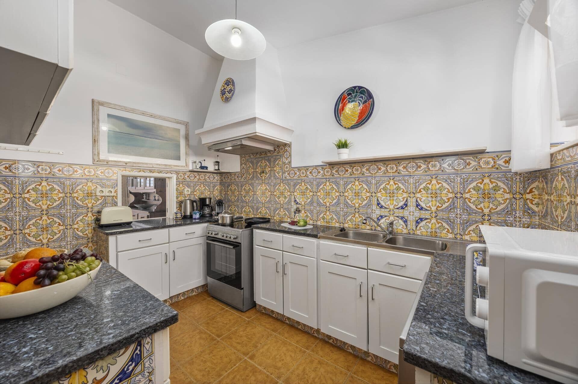 A kitchen with white cabinets, a stove, and a sink.