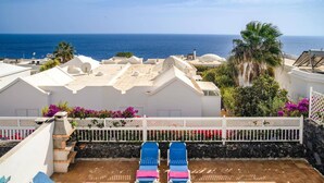 A rooftop pool area with two lounge chairs, a pool, and a view of the ocean. - Villa Calma by Villa Plus (Puerto del Carmen)