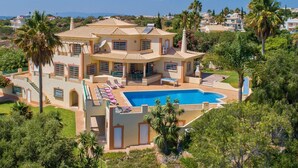 A large, multi-story house with a swimming pool, surrounded by palm trees and other greenery. - Villa Nenufa by Villa Plus (Albufeira)