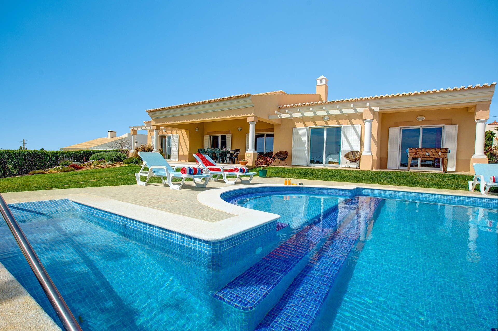 A swimming pool with lounge chairs and a patio area.