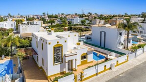 A residential area with white buildings, a swimming pool, and a clear blue sky. - Villa Anamar by Villa Plus (Albufeira)