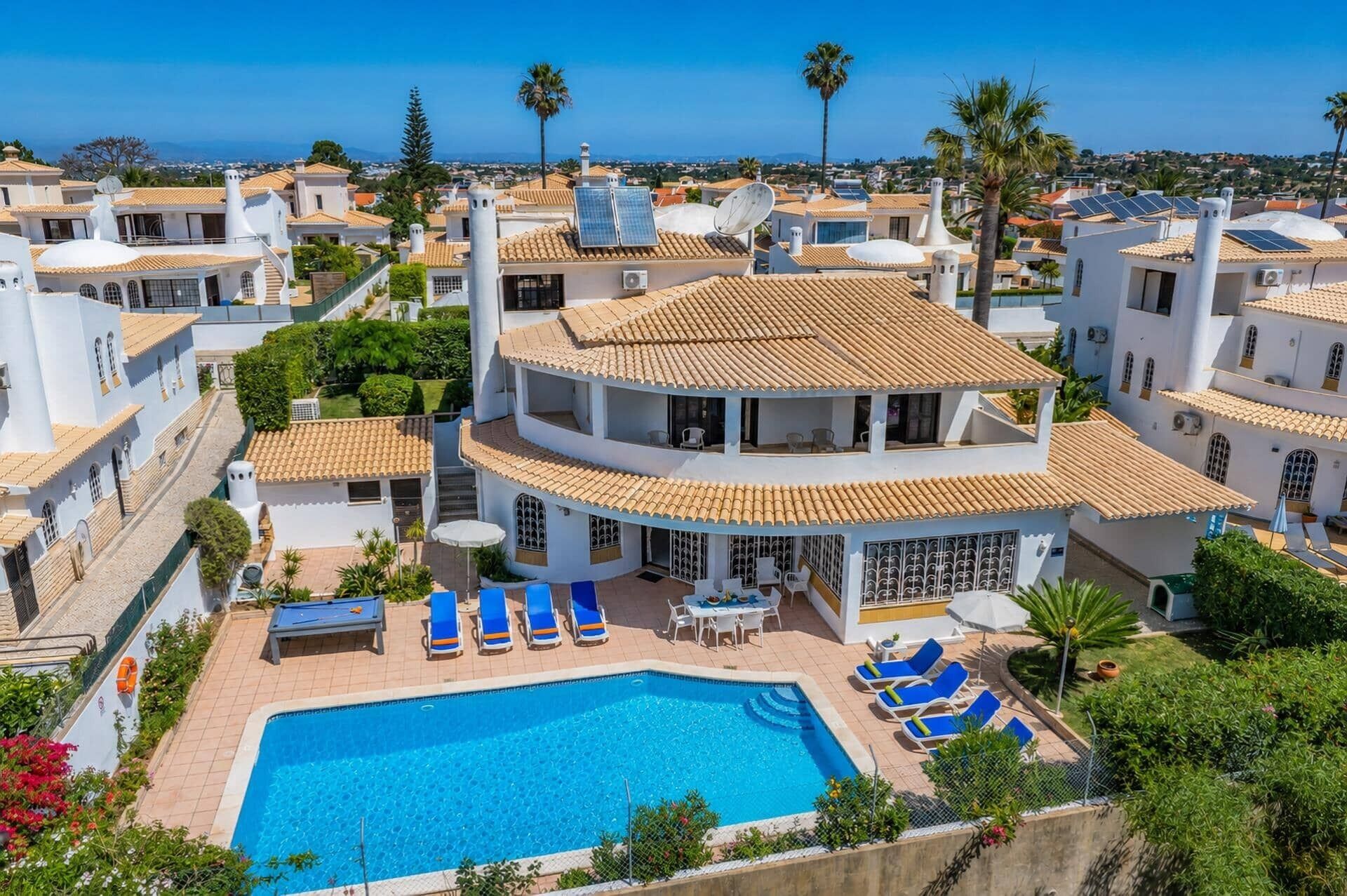 A residential building with a swimming pool, multiple balconies, and solar panels.