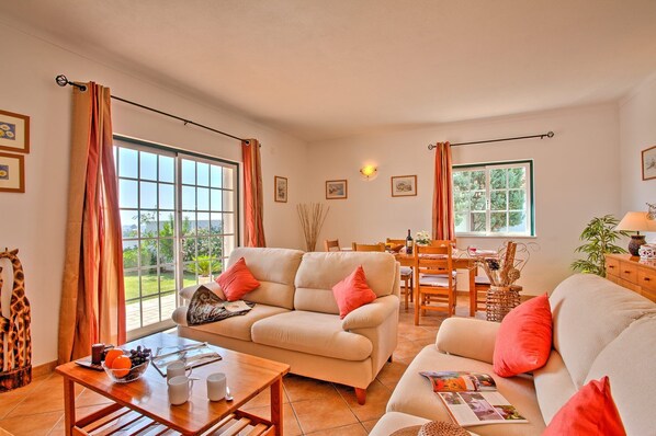 A cozy living room with two sofas, a coffee table, and a dining area with a table and chairs.
