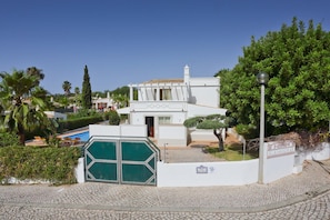 Stunning villa with a traditional Mediterranean facade, surrounded by lush greenery and a swimming pool.