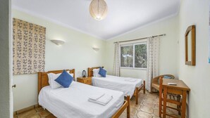 Une chambre avec deux lits, un bureau et une fenêtre.