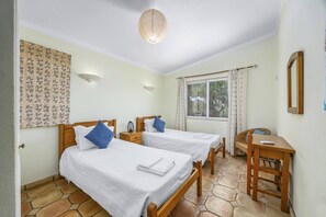 A room with two beds, a desk, and a window. - Villa Flor by Villa Plus (Guia)
