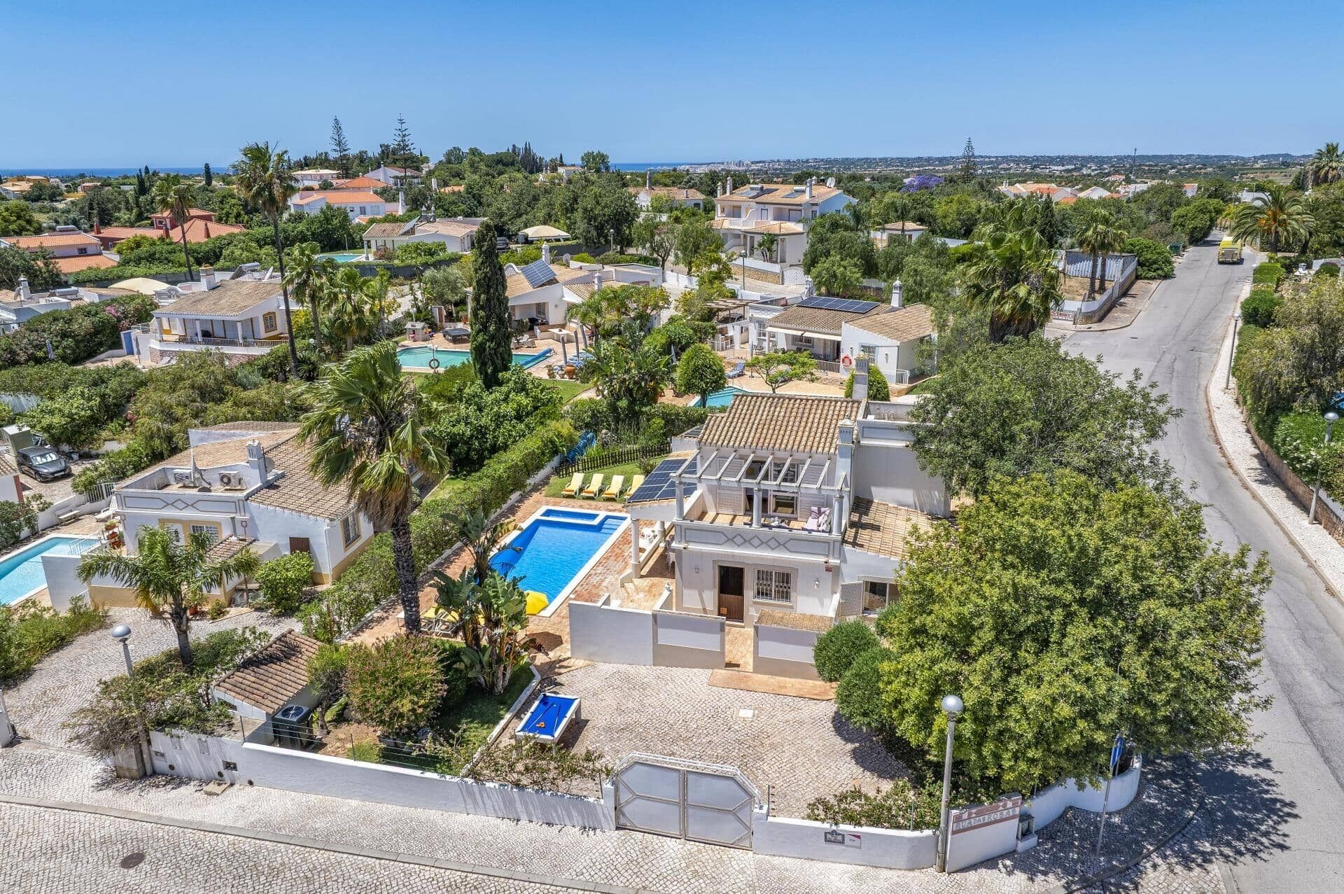 Un quartier résidentiel comprenant plusieurs maisons, une piscine et une rue.
