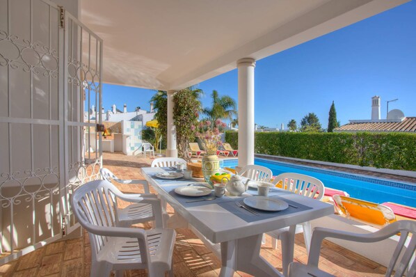 Enjoy a meal al fresco with a view of the pool from this outdoor dining area.