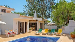 A pool area with a tiled pool, outdoor seating, and a building with a tiled roof. - Villa Lisson Grove by Villa Plus (Carvoeiro)